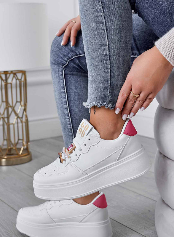 White sneakers with jeweled embellishments and fuchsia heel