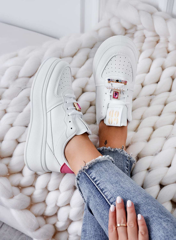 White sneakers with jeweled embellishments and fuchsia heel