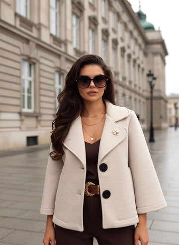 Abrigo corto beige con botones negros y broche