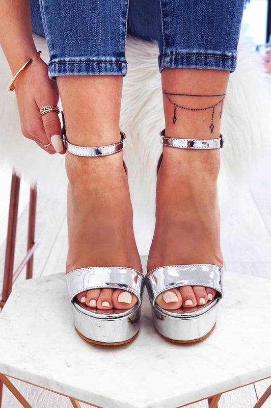 Silver patent sandals with high heel and ankle strap