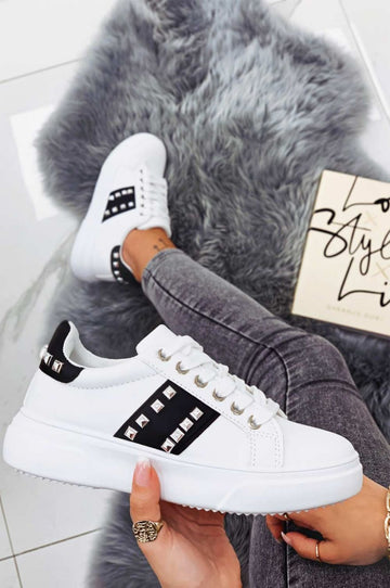 White sneakers with black inserts and studs