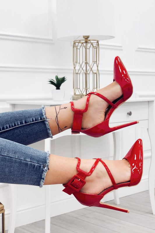 Zapatos de salón rojos de charol con tacón de aguja y hebilla