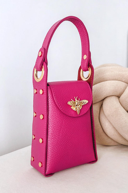 Bolso fucsia de mano con tachuelas doradas y correa extraíble